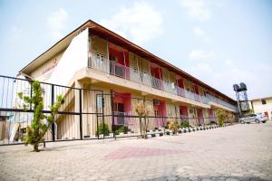 un edificio con una recinzione di fronte di Classicus Inn & Apartments a Ibadan