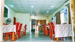 un comedor con sillas y mesas rojas en un restaurante en Classicus Inn & Apartments, en Ibadán