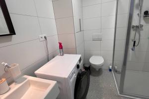 a white bathroom with a sink and a toilet at 2 room Apartment, terrace, new building Moruše in Prievoz