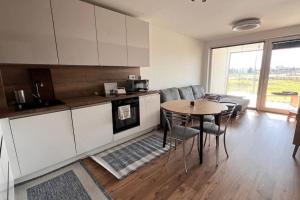 a kitchen and dining room with a table and chairs at 2 room Apartment, terrace, new building Moruše in Prievoz