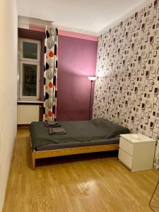 1 dormitorio con cama y pared púrpura en Wawel Apartament Centrum, en Cracovia