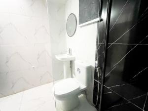 a white bathroom with a toilet and a mirror at luxe apartments in Lagos