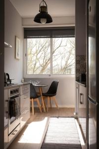 een keuken met een tafel en stoelen en een raam bij Lolla's City House in Porto