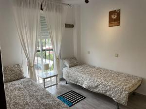 um quarto com 2 camas e uma janela em Almendros_Torremolinos em Torremolinos