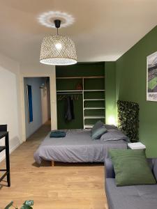 1 dormitorio con cama y pared verde en Le Wimbledon en Chalon-sur-Saône