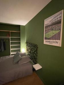 Habitación verde con cama y póster de un partido de béisbol en Le Wimbledon en Chalon-sur-Saône