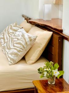 um quarto com uma cama com almofadas e uma mesa em Tai'inu Bungalows em Amuri