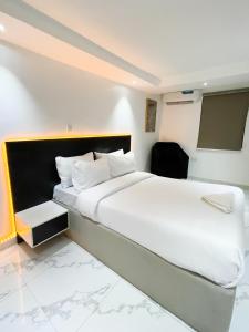 a bedroom with a large white bed and a tv at luxe apartments in Lagos