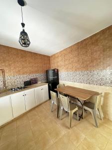 a kitchen with a table and chairs and a refrigerator at Dar Lamis in Houmt Souk