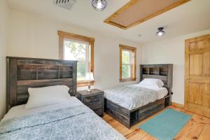 2 Betten in einem Schlafzimmer mit Holzböden und Fenstern in der Unterkunft Charming Biglerville Home with Patio and Yard! 