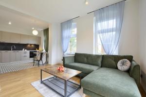 sala de estar con sofá verde y mesa en Apartament SUDETY en Boguszów-Gorce