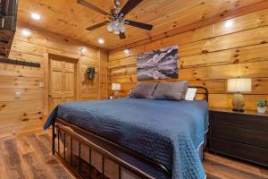 Rustic Mountain Retreat by Ghosal Luxury Lodging في بيدجن فورج: غرفة نوم بسرير في غرفة بجدران خشبية