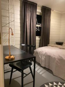 um quarto com uma secretária, um candeeiro e uma cama em På toppen av Tromsøya. Rett ut i naturen! em Tromsø