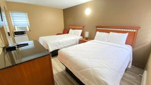 Habitación de hotel con 2 camas y barra. en Rolphton Motel and Restaurant, en Moor Lake Station