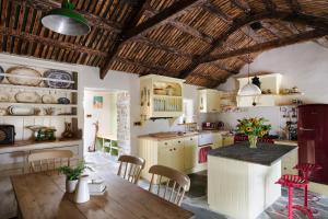 a kitchen with a table and chairs in a room at Secluded Thatched Cottage, near beaches & hill walking in Rashenny