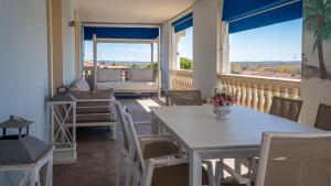 a dining room with a table and chairs on a balcony at Palladium Apt -Attico Vista Lago in centro Colombare, Sirmione in Sirmione