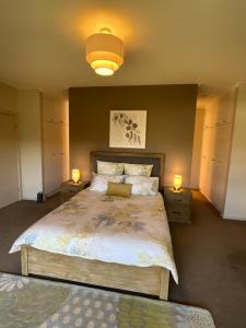 a bedroom with a large bed with two lights on it at A Scent of Lavender in Mount Gambier