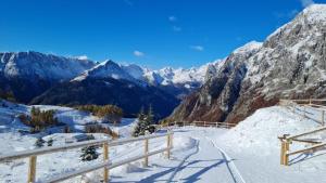 uma vista para uma serra nevada com montanhas cobertas de neve em Casa Pramosio em Paluzza