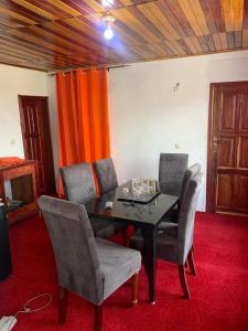 a dining room with a black table and chairs at Hotel La Rochelle in Bonamakolo
