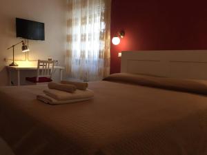 a bedroom with a bed with two towels on it at CAPOSTAZIONE22 in Pisa