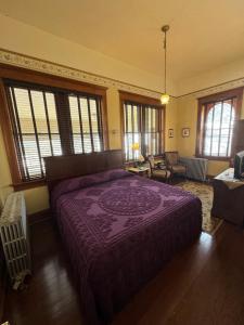 a bedroom with a purple bed in a room with windows at Cripple Creek Hospitality House & Travel Park in Cripple Creek