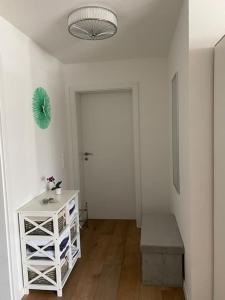 ein weißes Zimmer mit einem weißen Tisch und einer Tür in der Unterkunft Wohnstudio für bis zu 1-4 Personen nahe Bodensee in Stockach