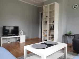 a living room with a white table and a tv at Bergsgatan 5 Arjeplog in Arjeplog