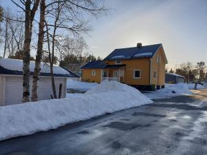 a house is covered in snow on a street at Bergsgatan 5 Arjeplog in Arjeplog