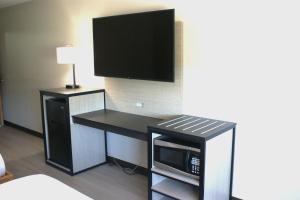 a room with a desk with a microwave and a tv at Van Buren Inn in Van Buren