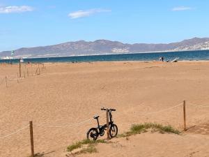 a bike parked on a sandy beach near the ocean at Villa Mercè Empúries in Sant Martí d’Empúries
