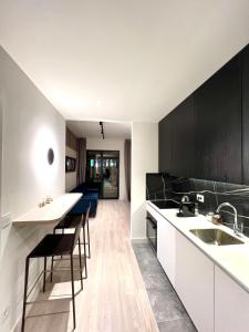 a kitchen with white counters and black cabinets at Belgrade Waterfront- Libera in Belgrade