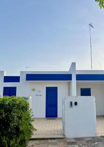 un edificio bianco e blu con una porta blu di Villetta da Leo a Torre dell'Orso