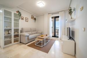 a living room with a couch and a tv at Wonderful Golf & Beach Apartment with front Seaview and Pool in Benalmádena