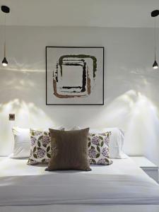 uma cama branca com almofadas e um quadro por cima em White legend studio room and two bedroom em Acra