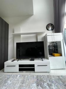 um centro de entretenimento branco com uma grande televisão de ecrã plano em White legend studio room and two bedroom em Acra