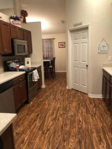 cocina con suelo de madera y puerta blanca en Vacation home near Tampa & Orlando, en Bartow