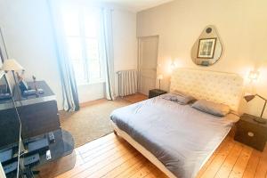 1 dormitorio con cama y espejo en la pared en House with garden 6 min from the beach, en Dinard
