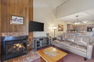 una sala de estar con un sofá y una chimenea en SNOW FLOWER 127 condo, en Park City