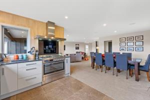 a kitchen and living room with a table and chairs at Lake Life Kinloch - Taupo Holiday Home in Taupo