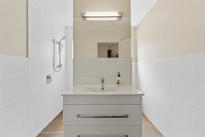 a white bathroom with a sink and a shower at Lake Life Kinloch - Taupo Holiday Home in Taupo +22 photos