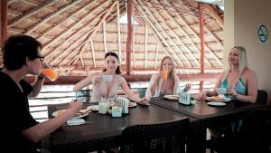 科蘇梅爾的住宿－LUNA AZUL BY UVAS，一群坐在桌子旁喝着饮料的人
