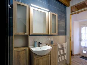 een badkamer met een wastafel en een spiegel bij La Fontaine, maison de charme à 12mn du Puy du Fou in Les Châtelliers-Châteaumur