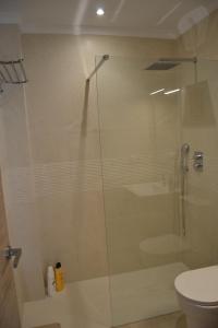 a glass shower in a bathroom with a toilet at Beach and Golf House Sotogrande - Torreguadiaro in Torreguadiaro +14 photos
