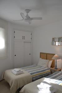 a bedroom with two beds and a ceiling fan at Beach and Golf House Sotogrande - Torreguadiaro in Torreguadiaro