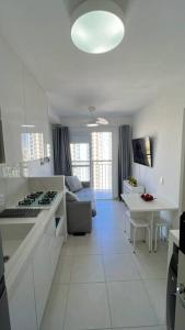 uma cozinha branca com um sofá e uma mesa em Chácara Santo Antônio 1 dormitório com sacada em São Paulo