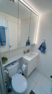a bathroom with a toilet and a sink and a mirror at Chácara Santo Antônio 1 dormitório com sacada in São Paulo