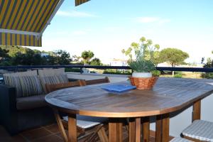 a wooden table with a potted plant on a patio at Beach House Sotogrande - Torreguadiaro in San Roque