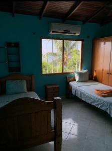 a blue room with two beds and a window at Mochima Inn 