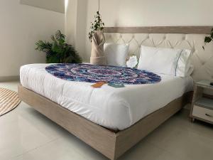1 dormitorio con 1 cama grande con sábanas blancas en Hotel Bolivariana Plaza Medellin en Medellín