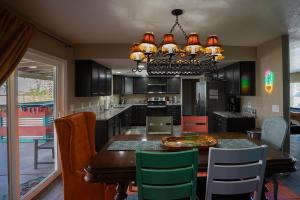 uma cozinha com uma mesa de jantar e um lustre em Modern Desert Delight! 4- bedrooms, pool, gameroom em Lake Havasu City